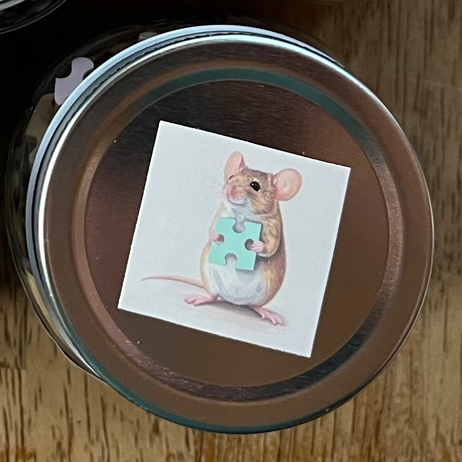 Collection of small jars with lids on a wooden surface, each containing a colorful card.